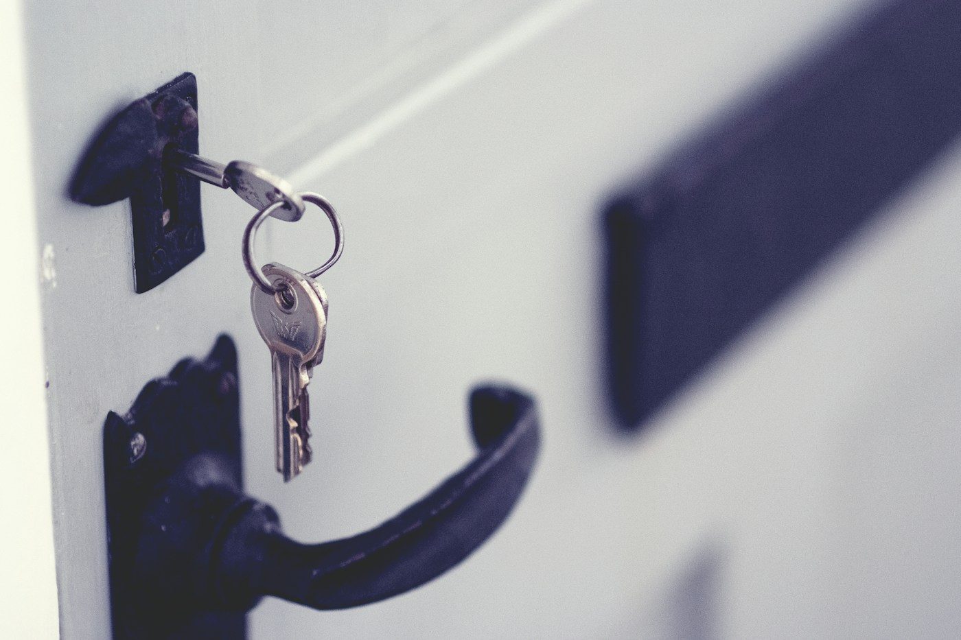 Chiave inserita nella serratura di una porta, accanto alla maniglia
